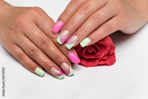summer mint pink manicure with silver stripes on long square tanned hands with a red rose in hands 