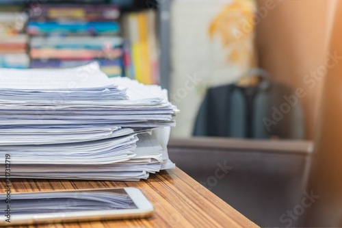 Pile of unfinished homework assignment documents of student on the teacher's desk. Stack of papers were not complete on table. © NuPenDekDee