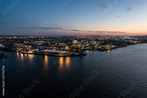 Aerial view of big cargo ship loading with containers at port of Hamburg, Germany. Beautiful sunset.