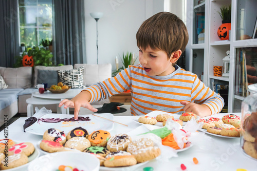 Boy decorating cookies for Halloween celebration