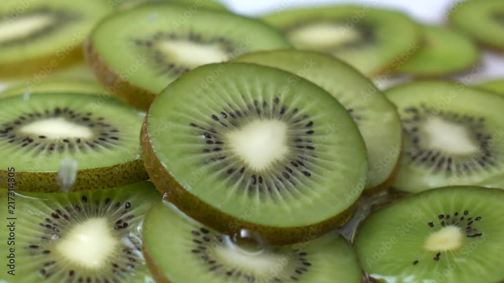 water splashing on a kiwi fruit in slow motion. water splashing on a kiwi fruit in slow motion.