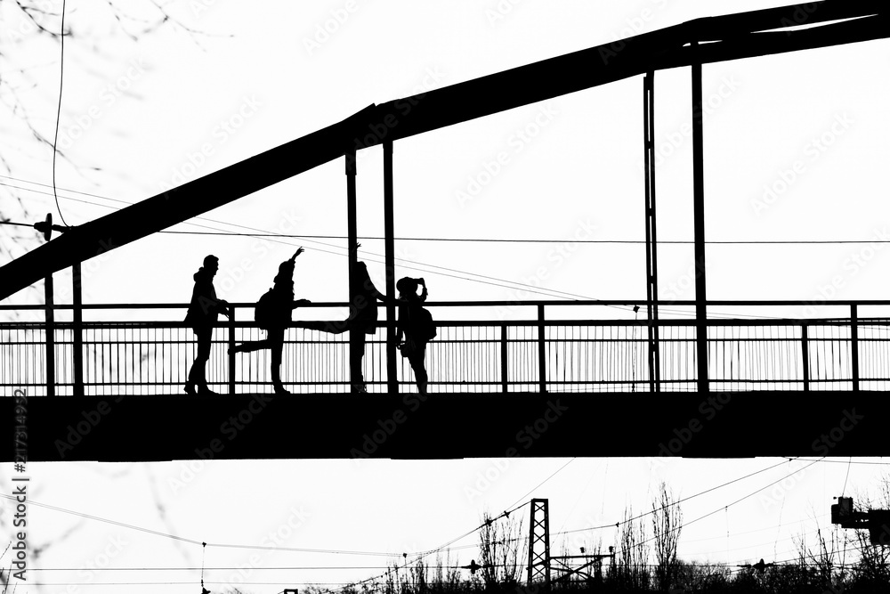 Silhouettes of people on the bridge posing with different poses for the photographer. Silhouettes of people on the bridge posing with different poses for the photographer.