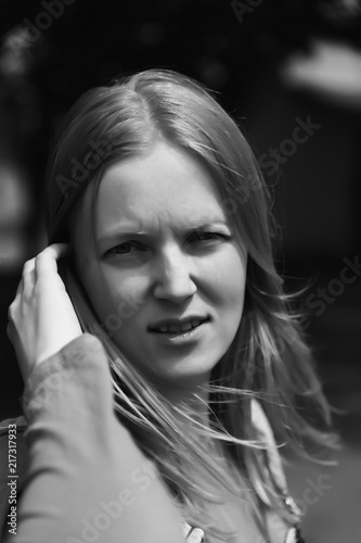street photo in the style of an old black and white film with grain - portrait of a woman in a busy city