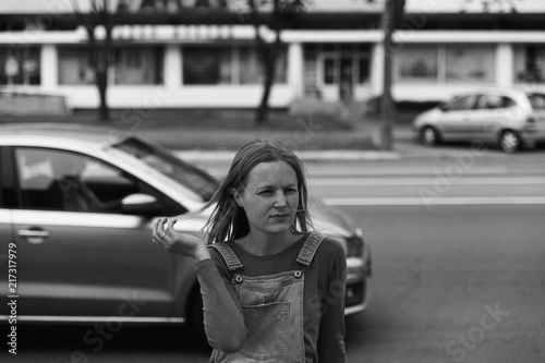 street photo in the style of an old black and white film with grain - portrait of a woman in a busy city