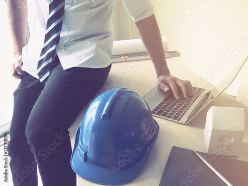 Engineer sitting on the table and working with laptop photo