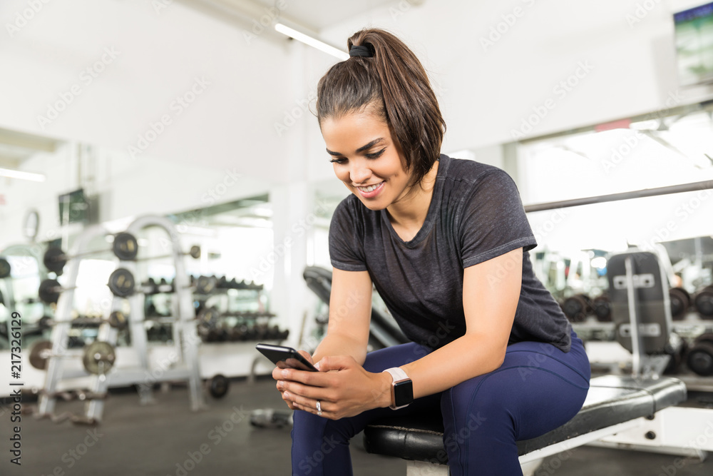 Smiling Fit Woman Using Smart Phone In Health Club Smiling Fit Woman Using Smart Phone In Health Club