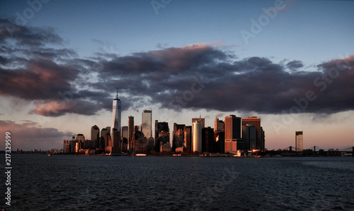 New York City skyline with urban skyscrapers over Hudson River at sunset. Manhattan downtown panorama. Waterfront view to the harbor at twilight.    