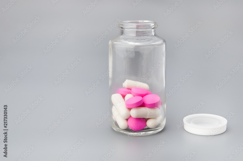 Large and bright red and white pills in a glass jar. Large and bright red and white pills in a glass jar.