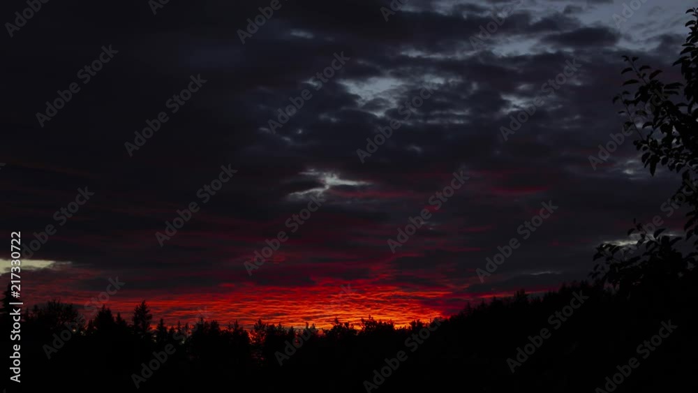 Sunset time lapse. Dramatic sky with moving clouds behind silhouette of trees, in rural Sweden. Sunset time lapse. Dramatic sky with moving clouds behind silhouette of trees, in rural Sweden.