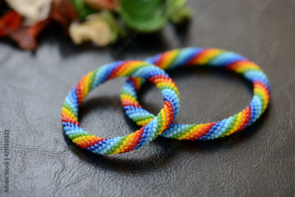 Set of rainbow bracelets for mother and daughter on a dark background close up Set of rainbow bracelets for mother and daughter on a dark background close up