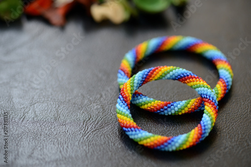 Set of rainbow bracelets for mother and daughter on a dark background close up