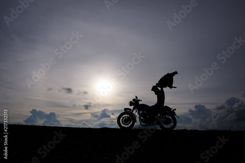 Motorcycle or motorbike Silhouette with male rider standing at the river. © Chayanin Wongpracha