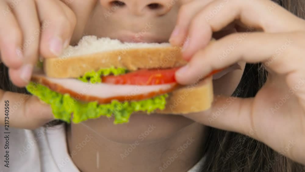 The child eats a sandwich. A close-up eating of sandwiches. The child eats a sandwich. A close-up eating of sandwiches.