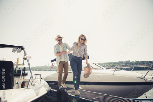 Handsome young man brought his girlfriend to the river to enjoy nature and take a ride on his speedboat.
