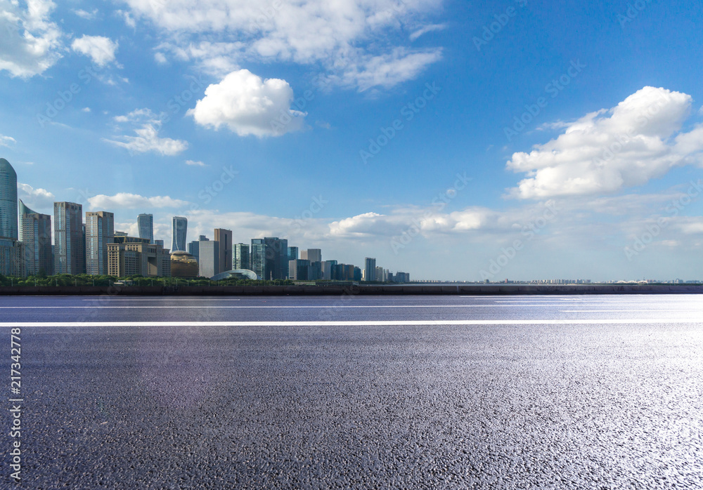 empty asphalt road with city skyline