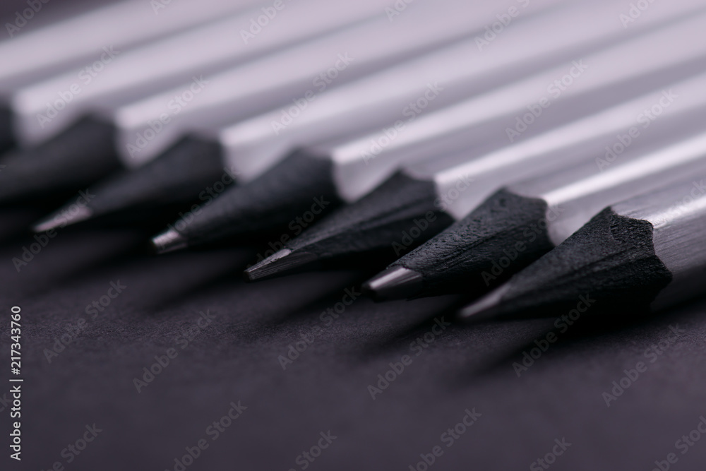 Gray sharpened pencils close-up on a dark background. Gray sharpened pencils close-up on a dark background.