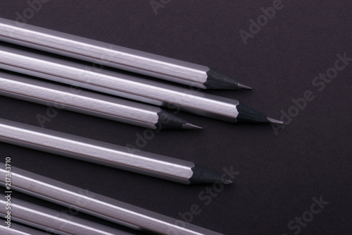 Gray sharpened pencils close-up on a dark background.