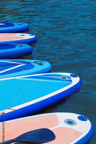 SUP Stand up paddle board on the background blue water.