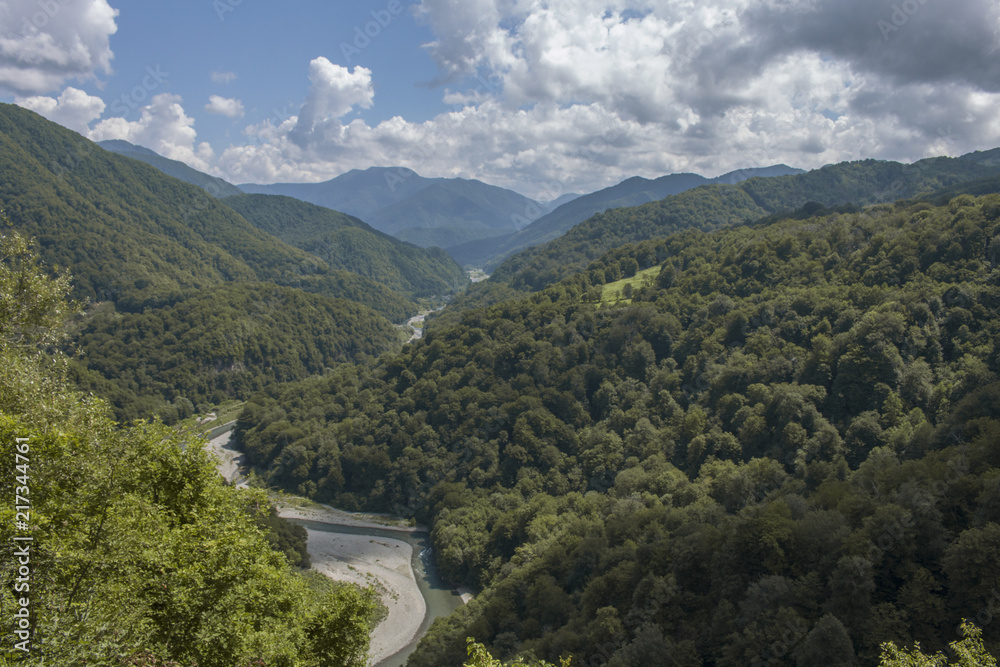 top view wild river flowing between green mountains on a clear summer day