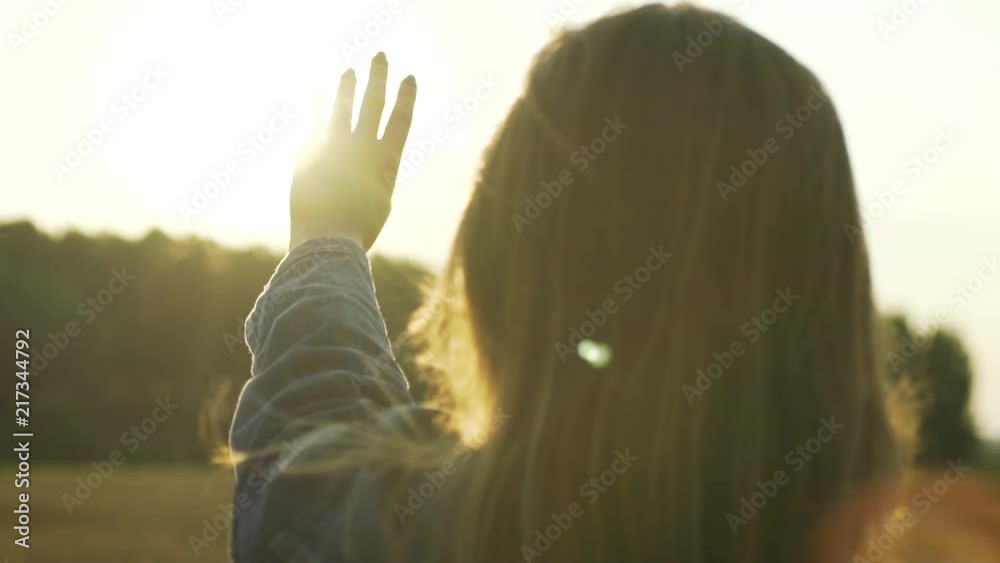 In this beautiful and cinematic slow motion close up footage you can see romantic hippie woman playing with sun rays during evening sunset. She is trying to catch the sun into palm with her fingers.