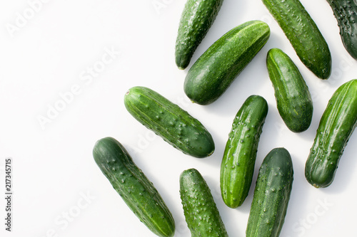 Many young cucumbers on a white background