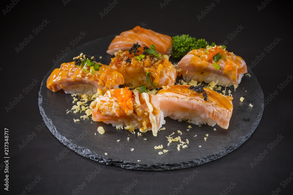Salmon Nigiri, Sushi salmon burned and topped with Shrimp Eggs and Tempura, traditional Japanese food on ceramic dish, Japanese food, Japanese Food menu, selective focus Salmon Nigiri, Sushi salmon burned and topped with Shrimp Eggs and Tempura, traditional Japanese food on ceramic dish, Japanese food, Japanese Food menu, selective focus