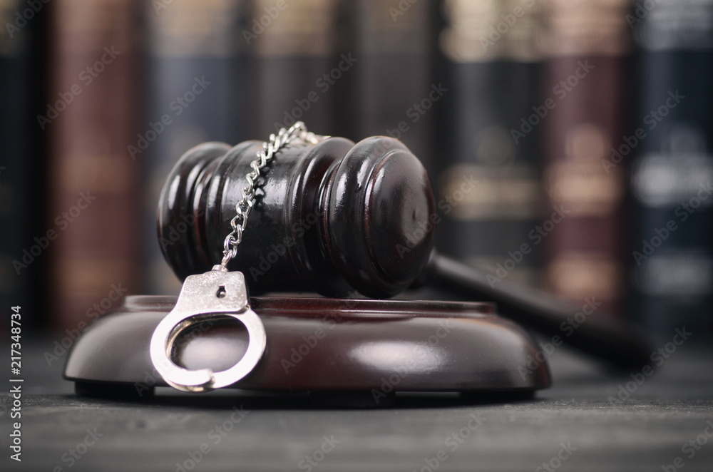  Judge Gavel and Handcuffs on a black wooden background.