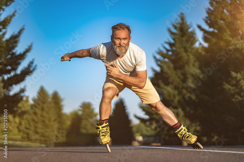 The old man rollerblading on the road