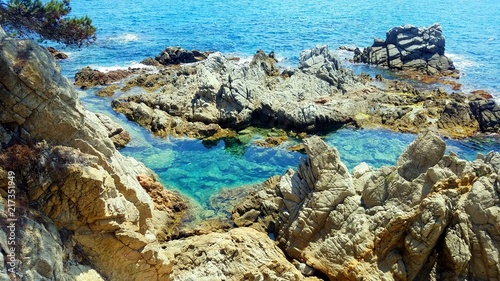 Rocks in blue sea. View on rocks in the Balearic sea. Postcard view on cliffs in the Balearic sea. Lloret de Mar sea view.