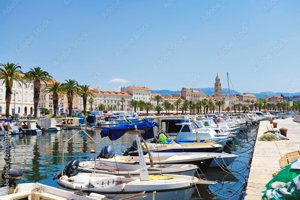 Obraz premium Split old city with the Riva palm promenade and the Diocletian palace from the pier with fisher boats in the foreground in Croatia