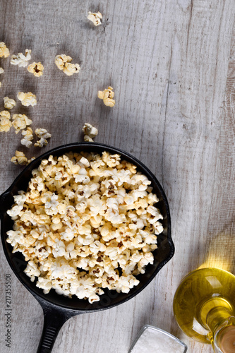  Prepared popcorn in frying pan, corn seeds in bowl and corncobs on kitchen table.Air salty popcorn. Salt popcorn on the wooden background . Chees .Popcorn texture