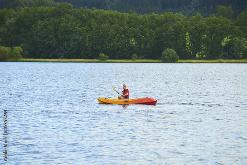 Active happy child. Teenage school boy having fun enjoying adventurous experience kayaking on the lake on a sunny day during summer vacation © Petr Bonek