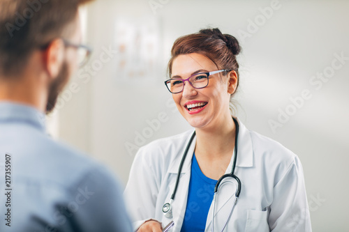 Woman Doctor talking to Patient at her Medical Office