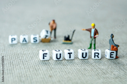 words past blurred and future sharp on grey background with miniature figurines