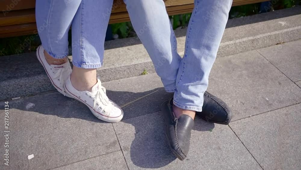 Man and woman are sitting on a bench outside in summer. Man and woman are sitting on a bench outside in summer.