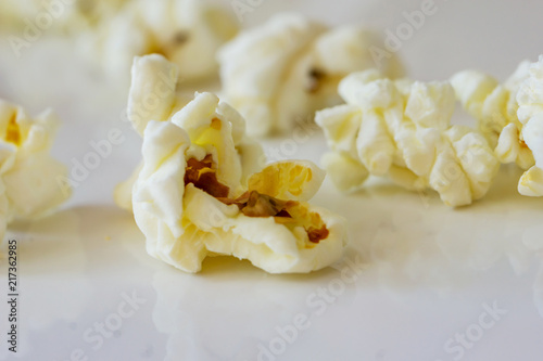 Close-up of a delicious popcorn texture on a white bacground. Shallow dept of field. Concept food by nature. © Ganka