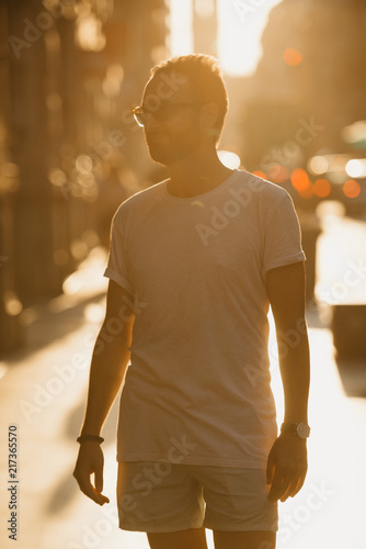 Obraz na płótnie Young man with beard posing in the rays of the sunset on the old European street in Spain w salonie