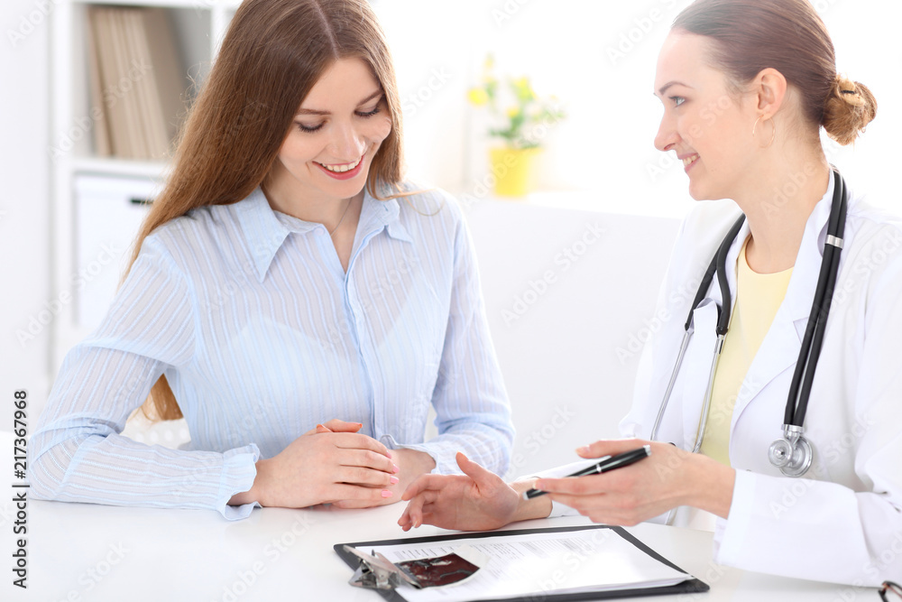 Doctor and patient sitting at the desk near window Doctor and patient sitting at the desk near window