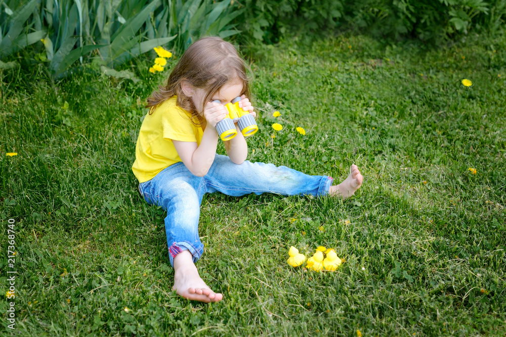 cute little girl playing with rubber duck and plastic binoculars outdoors. beautiful baby having fun with a toy duckling. home development of children. selective focus. cute little girl playing with rubber duck and plastic binoculars outdoors. beautiful baby having fun with a toy duckling. home development of children. selective focus.