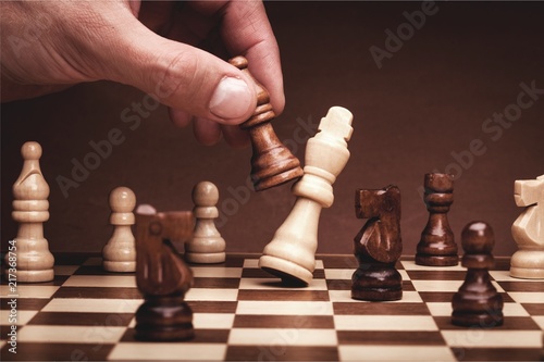 Businessman playing chess close up photo