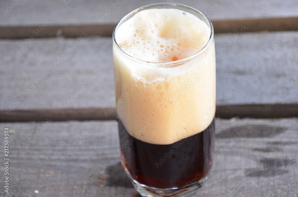 Glass of dark beer on the wooden background Glass of dark beer on the wooden background