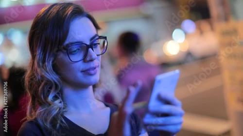 Woman using cellphone at night. Girl starring at smartphone screen in nightlife atmosphere4 photo