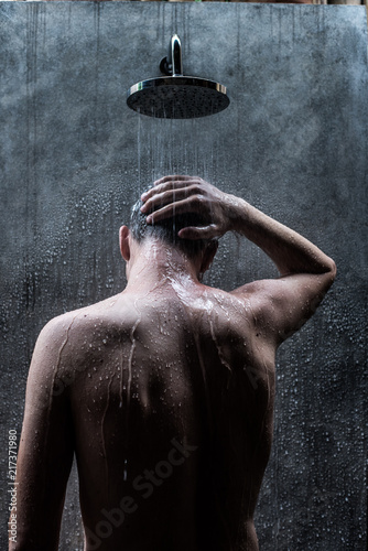 Handsome caucasian man taking a rain shower