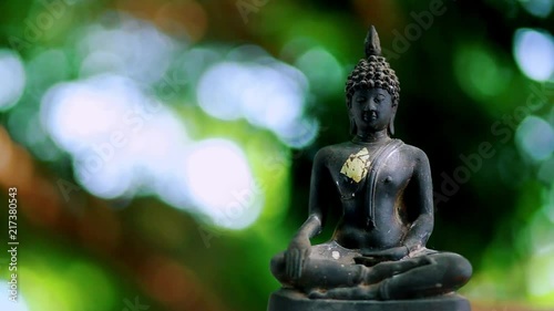 0ld Buddha statue with a natural bokeh background photo