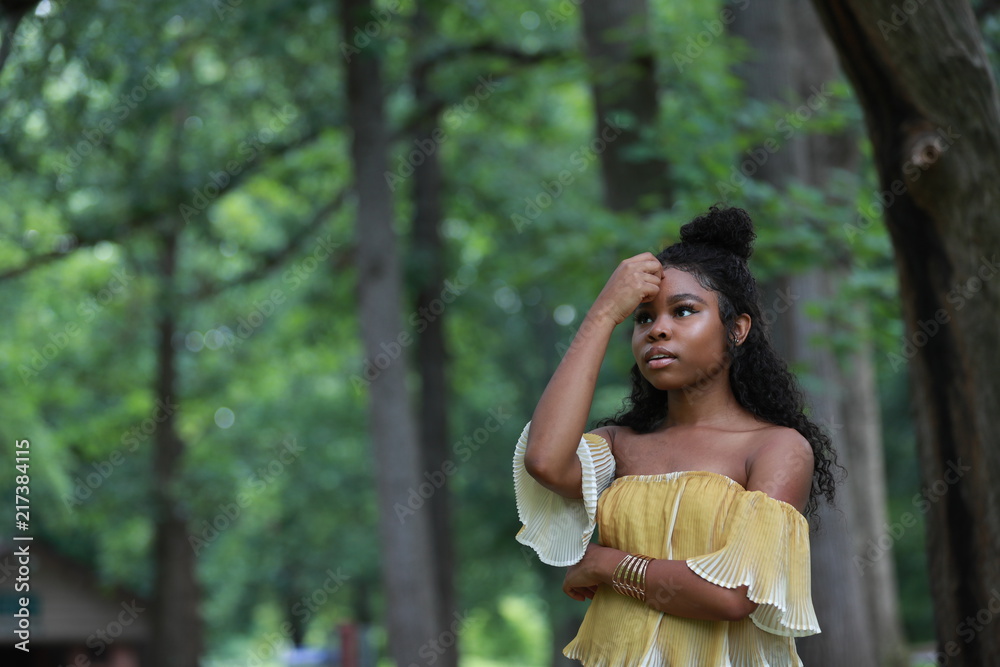 Young black woman praying in woods