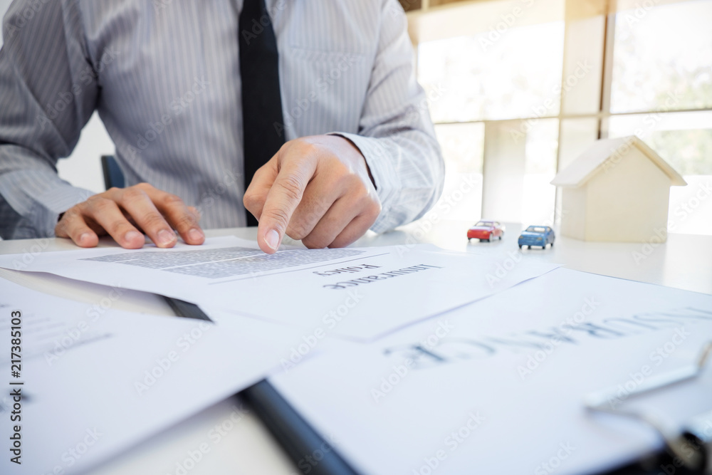 Car and Home insurance concept, customer making sign insurance form agreement, home and car model Car and Home insurance concept, customer making sign insurance form agreement, home and car model