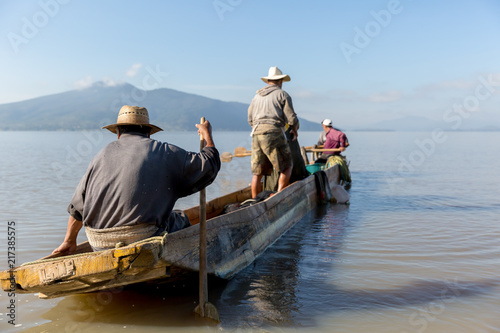 Hombres pescadores en laguna mexicana durante el amanecer