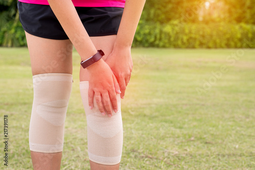Female using elastic bandage with her legs,Woman suffering from pain in leg injury after sport exercise running
