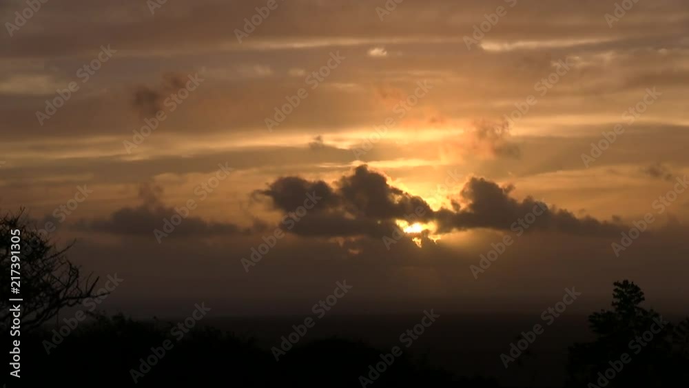 Early morning sunrise, the sun is rising thru the clouds, seen from land. Early morning sunrise, the sun is rising thru the clouds, seen from land.