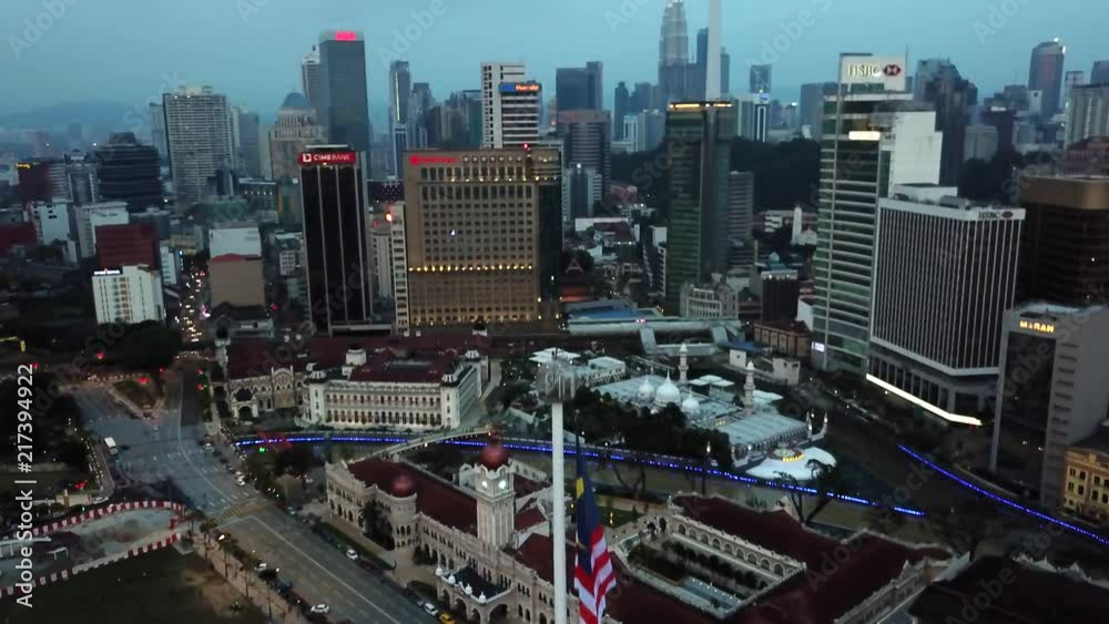 Aerial shot of a Malaysia Flag revealing Luala Lumpur on the background Aerial shot of a Malaysia Flag revealing Luala Lumpur on the background